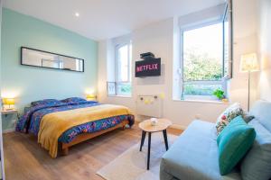 una camera da letto con un letto e un divano di Le Paisible I Centre ville & Quartier calme a Brest