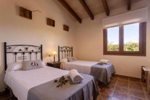 ein Schlafzimmer mit zwei Betten und einem Fenster in der Unterkunft Finca Sa Tanqueta Rústica in Inca + 33 Fotos