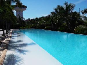 a large blue swimming pool with a tower in the background at Luxury Condo Mareia Ixtapa 101 in Ixtapa