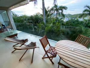 a balcony with a table and chairs and a view of the ocean at Luxury Condo Mareia Ixtapa 101 in Ixtapa
