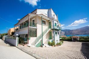 a white building with green balconies on a street at Panorama in Lixouri