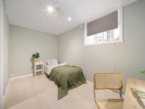 a white bedroom with a bed and a window at Stor leilighet i Bergen sentrum! in Bergen