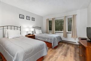 a bedroom with two beds and a flat screen tv at Highlands 05 with Wintergreen Advantage in Wintergreen +12 photos