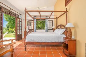 a bedroom with a canopy bed and a window at Villa d'exception tout confort avec piscine privée et jardin tropical in Quartier Morne la Valeur +20 photos