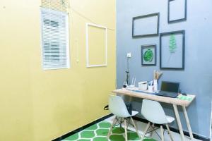 a room with a desk with a laptop and two chairs at karangjambe tnbts in Gadang