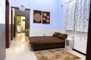 a living room with a brown couch and a blue wall at karangjambe tnbts in Gadang