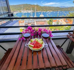 a table with a plate of watermelon and two glasses of wine at Mykonut Boutique Suites in Fethiye