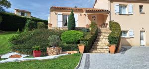 a house with a staircase in front of a yard at Chambre d'hôte chez Nathalie & Roland in Massiac