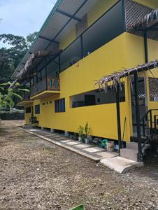 Un edificio amarillo con plantas delante. en APARTAMENTO La FONTE de Puerto Viejo Limón, en Puerto Viejo