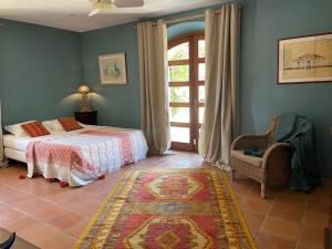 Un dormitorio con una cama y una ventana y una silla. en Mas Vigneron, en Gruissan