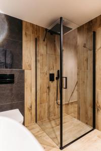 a bathroom with a shower with wooden walls at Grand Chalet Lacu Rosu in Lacu Rosu +19 photos