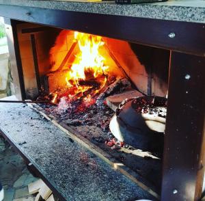 a fire in a fireplace with a cake in it at Little paradise house in Lič +10 photos