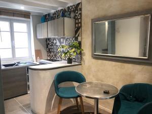 une cuisine avec une table, deux chaises et un comptoir dans l'établissement La Petite Maison, à Survilliers 15 autres photos