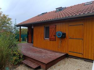 a house with a wooden deck with a door at La Cachotière du Lac in Giffaumont-Champaubert +12 photos