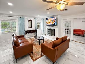 a living room with two couches and a fireplace at Baywatch Paradice Bayfront, private pier, Sleeps 8 Fenced Dog Area 8 m to beach in Gulf Shores