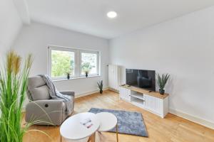 Una sala de estar con una silla y un televisor. en Gestade Fewo 4, en Bernkastel-Kues