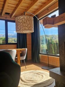 a living room with a floor lamp and a table at Cabana 278 in Moieciu de Jos