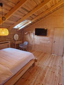a bedroom with a bed and a tv on a wall at Cabana 278 in Moieciu de Jos +33 photos