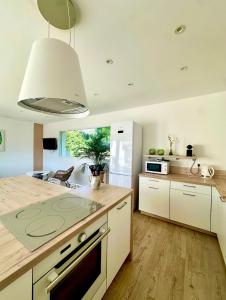 a kitchen with white cabinets and a stove top oven at VILLA JUWEN in Oletta