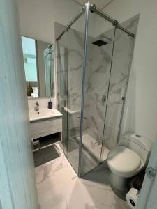 a bathroom with a shower and a toilet and a sink at Bello Horizonte-sector Hilton -irotama in Playa Bello Horizonte