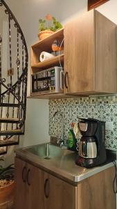a kitchen counter with a sink and a microwave at Volarte Hotel in Jardin +43 photos