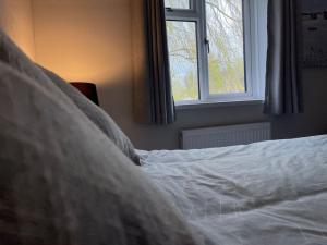 een wit bed met een raam in een slaapkamer bij Cosy Clos Y Hendy Lodge in Penbryn +27 foto's
