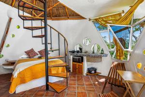a bedroom with a bed and a spiral staircase at Villa Heliconia in Barra de Navidad