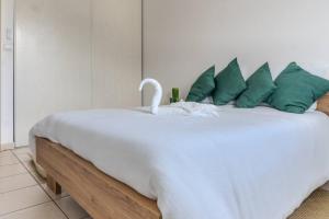 a white bed with a swan sitting on top of it at Cactus appartement T4 in Saint-Denis
