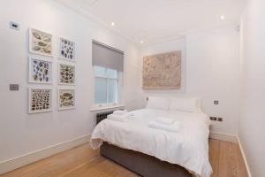 a white bedroom with a bed with two towels on it at Museum View in London