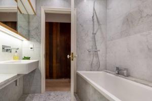 a bathroom with a tub and a sink and a shower at Museum View in London