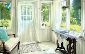 a room with a table and a chair and windows at Three-Bedroom Holiday Home In Hultsfred in Skinshult