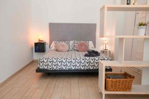 Un dormitorio con una cama con almohadas encima. en Vintage duplex with jacuzzi, en Málaga