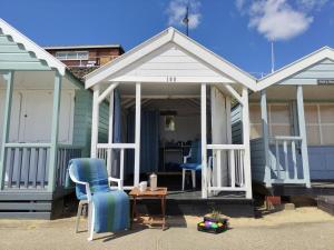 a house with a porch with two chairs and a table at Chestnutt Cottage, Reydon in Reydon