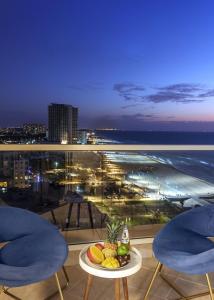 バト・ヤムにあるUrban Beach Apartmentsのバルコニーのテーブルに盛られた果物