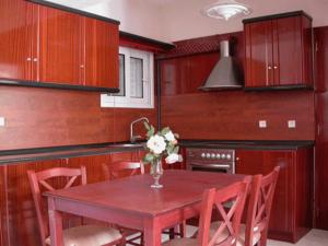 a kitchen with a wooden table with a vase of flowers on it at Lihas Studios in Agios Georgios