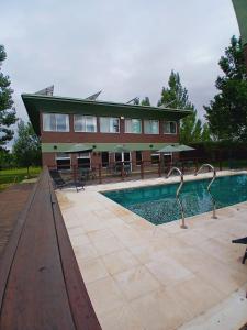 a building with a swimming pool in front of a building at La Divina Pereza Eco in San Rafael