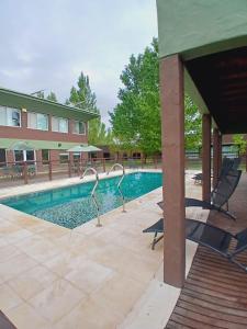 a swimming pool with chairs next to a building at La Divina Pereza Eco in San Rafael