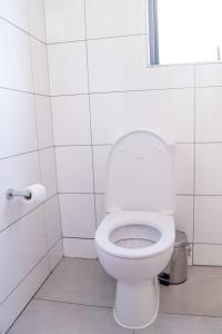 bagno bianco con servizi igienici e carta igienica di 7 Elizabeth Place - Beautiful self catering 1 bedroom unit next to Kyalami Racetrack with free WiFi - swimming pool gym and restaurant - Perfect for a couple in Midrand Waterfall a Midrand