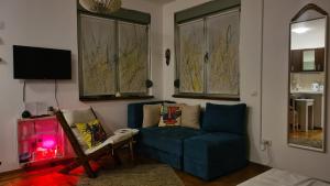 a living room with a blue couch and a chair at Apartman BelLe in Belgrade
