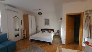 a bedroom with a bed and a blue couch at Apartman BelLe in Belgrade