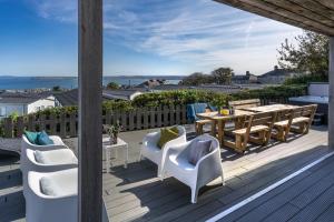 una terraza con mesa y sillas de madera, mesa, mesa y sillas en Chy Lowen, en St Ives