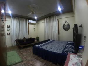 a bedroom with a bed and a chair in it at Kashmir Cottage Muzaffarabad in Muzaffarabad