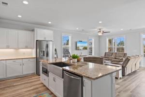 an open kitchen and living room with white cabinets at It's Nautical Nonsense Oceanview 4 bedroom, 4 bath in Pawleys Island
