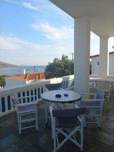 a table and chairs on a balcony with a view of the ocean at Lilian 1 in Batsi