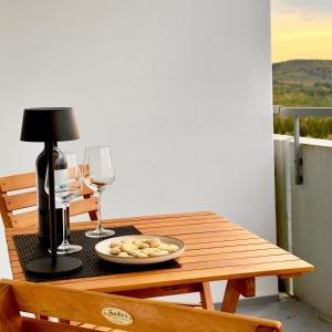 a table with wine glasses and a plate of food on it at M&D Apartments nähe Stadion mit Klimaanlage - Netflix - Küche - Sunset View - Balkon in Kaiserslautern