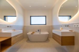 un bagno con due lavandini e due specchi di Villa Paola a Pianottoli-Caldarello