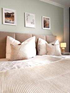 a bedroom with a bed with white sheets and pillows at M&D Apartments nähe Stadion mit Klimaanlage - Netflix - Küche - Sunset View - Balkon in Kaiserslautern