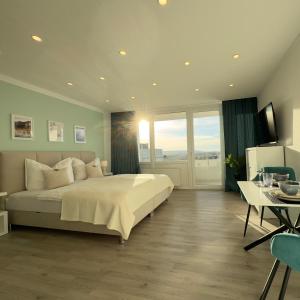 a large bedroom with a large bed and a table at M&D Apartments nähe Stadion mit Klimaanlage - Netflix - Küche - Sunset View - Balkon in Kaiserslautern
