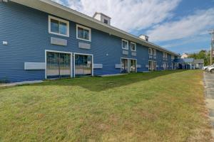 ノースコンウェイにあるYankee Clipper Inn, SureStay Collection by Best Westernの前に広い庭がある青い建物