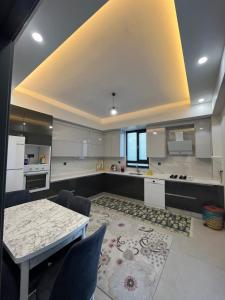 a large kitchen with a table and a counter top at Havuzlu Villa-Kartepe in Masukiye